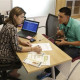 Navigator Dianelys Dominguez, left, assists Giovanny Vega, 18, of Miami, right, sign up for health insurance under the Affordable Care Act at the Borinquen Medical Center in Miami. Florida has eclipsed California to become the state with the highest number of consumers buying health coverage through new insurance markets under