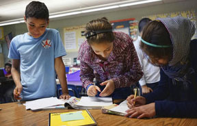 Abdulhamid Ashehneh, 12, warks on English language exercises with fellow students in a class filled with refugee children at Cajon Valley Middle in El cajon, Calif